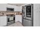 Well-lit kitchen featuring stainless steel appliances and white cabinetry at 12605 W Dreyfus Dr, El Mirage, AZ 85335