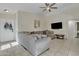 Living room featuring tile floors, a ceiling fan, large gray sectional, and a TV at 12605 W Dreyfus Dr, El Mirage, AZ 85335