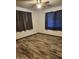 This bedroom showcases beautiful hardwood floors, complemented by matching wooden trim, and two sunlit windows at 12607 N 23Rd St, Phoenix, AZ 85022