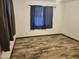 This bedroom features beautiful hardwood floors, complemented by matching wooden trim, and two sunlit windows at 12607 N 23Rd St, Phoenix, AZ 85022