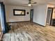 Open living room with wood floors, ceiling fan, large mirror, and view into the kitchen area at 12607 N 23Rd St, Phoenix, AZ 85022
