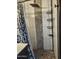 The shower offers a rainfall shower head, a stone accent wall, a shower caddy, and a floor made of stones at 12607 N 23Rd St, Phoenix, AZ 85022