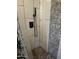 The shower features a black shower head and wall control against a stone accent wall and stone floor at 12607 N 23Rd St, Phoenix, AZ 85022