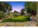 Backyard featuring putting green, outdoor fire pit and desert landscaping at 13034 N 69Th St, Scottsdale, AZ 85254