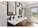 Bathroom with wood vanity, marble countertop, black fixtures and framed mirror at 13034 N 69Th St, Scottsdale, AZ 85254