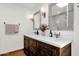 Bathroom featuring a wood double vanity, quartz countertop, decorative mirrors, and modern fixtures at 13034 N 69Th St, Scottsdale, AZ 85254