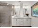 Bright bathroom featuring double sinks, white cabinets, granite countertops and glass shower at 13034 N 69Th St, Scottsdale, AZ 85254