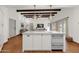 Bright kitchen with white cabinets, terra-cotta tile floors, and wooden ceiling beams in an open concept living space at 13034 N 69Th St, Scottsdale, AZ 85254