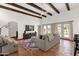 Cozy living room with wood-beamed ceiling, terra-cotta tile floors, and French doors leading to the backyard at 13034 N 69Th St, Scottsdale, AZ 85254