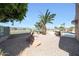 Desert landscaped backyard featuring palm tree, golf course view, and privacy fence at 13458 W Coronado Rd, Goodyear, AZ 85395