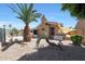 Backyard featuring desert landscaping, palm tree, and covered patio area at 13458 W Coronado Rd, Goodyear, AZ 85395