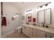 Modern bathroom with a walk-in shower, dual sinks, and granite countertops at 13458 W Coronado Rd, Goodyear, AZ 85395
