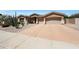 Attractive single-story home featuring a large driveway, a three-car garage, and desert-friendly landscaping at 13458 W Coronado Rd, Goodyear, AZ 85395