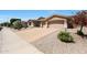 Attractive single-story home featuring a large driveway, a three-car garage, and desert-friendly landscaping at 13458 W Coronado Rd, Goodyear, AZ 85395