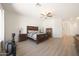 Spacious main bedroom featuring a ceiling fan, wood floors, and a comfortable bed at 13458 W Coronado Rd, Goodyear, AZ 85395