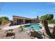 Beautiful backyard featuring a freeform pool, covered patio, and desert landscaping at 13458 W Coronado Rd, Goodyear, AZ 85395