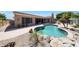 Inviting backyard with a sparkling pool, rock features, and desert landscaping at 13458 W Coronado Rd, Goodyear, AZ 85395