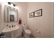 This powder room has a floating sink and framed art pieces at 13458 W Coronado Rd, Goodyear, AZ 85395