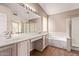 Bathroom featuring dual sinks, a vanity area, and a separate tub and shower at 1424 W Mead Dr, Chandler, AZ 85248