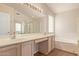 Bathroom featuring double sinks, large mirror with vanity lighting, separate shower, and a soaking tub at 1424 W Mead Dr, Chandler, AZ 85248