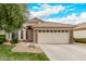 Inviting home featuring a well-kept lawn, stone accents, and a spacious two-car garage at 1424 W Mead Dr, Chandler, AZ 85248