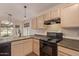 Functional kitchen featuring oak cabinets, black appliances, and ample counter space for meal preparation at 1424 W Mead Dr, Chandler, AZ 85248