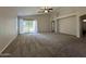 Open-concept living room with neutral walls, carpet, and sliding doors to the backyard at 1424 W Mead Dr, Chandler, AZ 85248