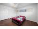 Cozy bedroom featuring wood floors, a ceiling fan, and built-in closet space for ample storage at 1431 E 1St St, Mesa, AZ 85203