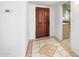Bright entryway featuring tile flooring, a wooden front door, and a glimpse into the kitchen at 1431 E 1St St, Mesa, AZ 85203