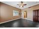 Spacious bedroom features a ceiling fan, a window with bright light, and a dark accent door at 1435 E Rancho Dr, Phoenix, AZ 85014