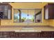 Bright kitchen showcases granite countertops, a window overlooking the yard, and custom cabinetry at 1435 E Rancho Dr, Phoenix, AZ 85014
