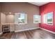Bright living room with a wet bar, wood floors, open windows, and light-colored walls at 1435 E Rancho Dr, Phoenix, AZ 85014