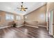 Expansive living room with wood floors, a ceiling fan, and multiple windows offering plenty of natural light at 1435 E Rancho Dr, Phoenix, AZ 85014