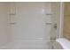 Bright white bathtub featuring built in shelving and chrome fixtures at 151 E Broadway Rd # 206, Tempe, AZ 85282