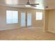 Bright living room with neutral carpet, ceiling fan, and french doors leading to outdoor balcony at 151 E Broadway Rd # 206, Tempe, AZ 85282