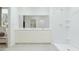 Bright bathroom features a double vanity, large mirror and a shower with built-in shelves at 15597 W Williams St, Goodyear, AZ 85338