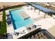 Aerial view of a community pool with clear blue water, lounge chairs, and well-maintained landscaping at 15597 W Williams St, Goodyear, AZ 85338