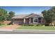 Charming single-story home featuring a two-car garage, brick driveway, and a beautifully landscaped front yard at 15797 W Kendall St, Goodyear, AZ 85338