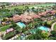 Stunning aerial view of the community clubhouse with pools, lush landscaping, and a parking area near the golf course at 1804 E Sattoo Way, Queen Creek, AZ 85140