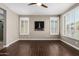Bright bedroom featuring hardwood floors, a ceiling fan, and large windows with plantation shutters at 1804 E Sattoo Way, Queen Creek, AZ 85140
