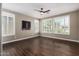 Bright bedroom featuring hardwood floors, a ceiling fan, and large windows with plantation shutters at 1804 E Sattoo Way, Queen Creek, AZ 85140