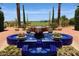 Elegant blue tiled fountain set in a beautifully landscaped courtyard with flowers and palm trees at 1804 E Sattoo Way, Queen Creek, AZ 85140