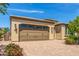 Two-car garage of a home with a low-pitched roof and desert landscaping at 1804 E Sattoo Way, Queen Creek, AZ 85140