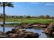Beautiful golf course view with a serene pond, lush greenery, and scenic mountains in the background at 1804 E Sattoo Way, Queen Creek, AZ 85140