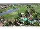 Scenic view of the community's lush golf course with a pond, sand traps, and palm trees near swimming pool at 1804 E Sattoo Way, Queen Creek, AZ 85140