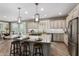 Spacious kitchen featuring island, granite counters, stainless appliances, breakfast bar, and custom cabinetry at 1804 E Sattoo Way, Queen Creek, AZ 85140