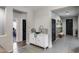 Hallway with tile flooring, white storage cabinet, and doors leading to various rooms at 20142 N 260Th Dr, Buckeye, AZ 85396