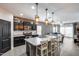 Open kitchen featuring dark cabinets, granite counters, an island with pendant lighting, and stainless steel appliances at 20142 N 260Th Dr, Buckeye, AZ 85396