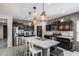 Modern kitchen features black cabinets, stainless steel appliances, a large island with seating, and pendant lighting at 20142 N 260Th Dr, Buckeye, AZ 85396