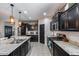 Well-equipped kitchen with granite counters, stainless appliances, dark cabinets, and tile flooring at 20142 N 260Th Dr, Buckeye, AZ 85396